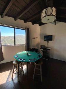 Zimmer mit einem Tisch, 2 Stühlen und einem TV in der Unterkunft Cabaña Valzam 2 entre viñedos Rancho Tecate Resort in Tecate