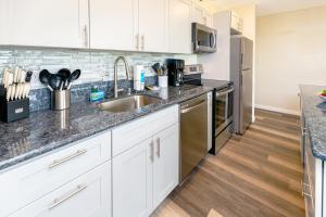 a kitchen with white cabinets and a sink at Panoramic Mountain View Condo with Free Parking! in Honolulu