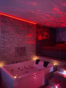 una vasca da bagno in una stanza con illuminazione rossa di Sweetlove Spa a Terracina