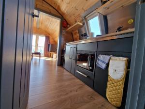 a kitchen with a stove and a microwave at Dalrigh Pod in Onich