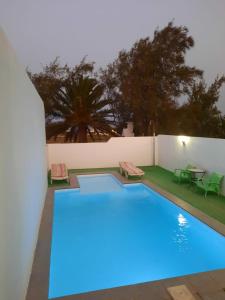 a swimming pool with blue lighting in a backyard at LA CALDERETA CASA RURAL in La Oliva