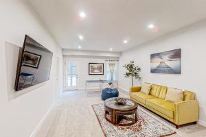 a living room with a yellow couch and a table at A Home Away from Home in North Myrtle Beach