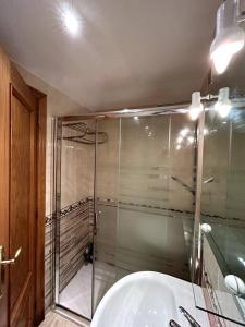 La salle de bains est pourvue d'une douche en verre et d'un lavabo. dans l'établissement Oropesa del Mar Inn, à Oropesa del Mar