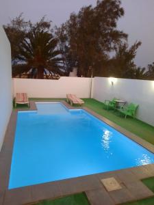 a swimming pool with blue lighting in a backyard at LA CALDERETA CASA RURAL in La Oliva