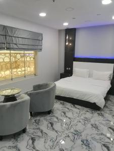 Habitación de hotel con 1 cama y 2 sillas en Marina, en Sohar