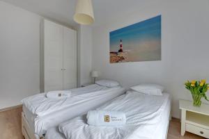 Cette chambre blanche dispose de 2 lits et d'un phare. dans l'établissement Marina - Chmielna Superior, à Gdańsk