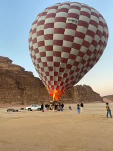 eine Gruppe von Personen, die unter einem Heißluftballon stehen in der Unterkunft Travel Wadi Rum in Wadi Rum