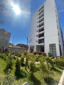 un edificio con un árbol delante de un edificio en Center Tirana Apartments, en Tirana