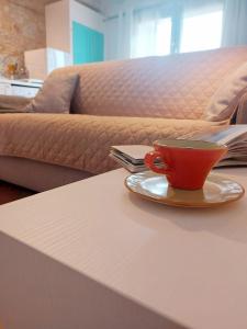 una taza de café roja en una mesa con sofá en La casa di Elvira2, en Castelnuovo Berardenga