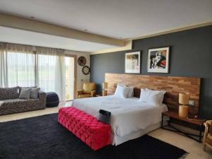 a bedroom with a large bed with a red bench at Villa de rêve à Marrakech in Marrakesh