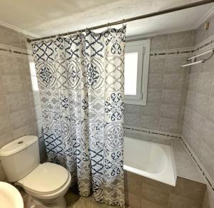 a bathroom with a toilet and a shower curtain at Anatoli House in Gaios