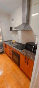 kuchnia ze zlewem i kuchenką mikrofalową w obiekcie Pedregalejo Playa, Piscina y Parking w Maladze