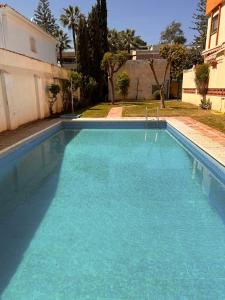 basen z niebieską wodą przed domem w obiekcie Pedregalejo Playa, Piscina y Parking w Maladze