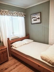 1 dormitorio con cama y ventana en Stuga i Furudal (nära Rättvik), en Furudal