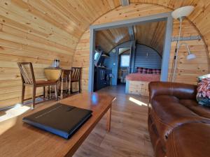 a living room with a couch and a table at Dalrigh Pod in Onich