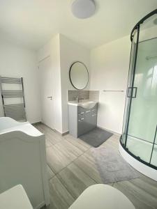 a white bathroom with a sink and a mirror at Gatwick Deluxe En-suite Rooms in Horley