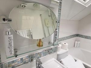a bathroom with a mirror and a sink and a tub at Ystabl in Llannon