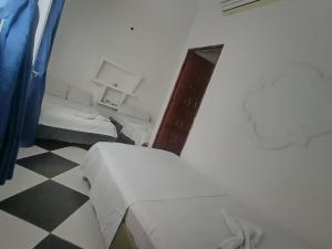 Habitación con 2 camas y suelo a cuadros. en Hotel El Paisano en Villavicencio