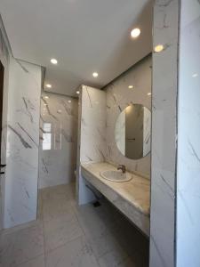een witte badkamer met een wastafel en een spiegel bij Hero's Chalet - Deadsea in Al Rama