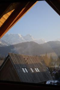 a view of a mountain range from a window at Górski Domek Zakopane in Kościelisko