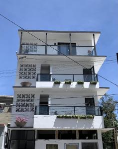 a tall white building with flowers on the balconies at La Calma Poshtel in San Juan