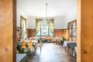 ein Esszimmer mit Tischen, Stühlen und einem Fenster in der Unterkunft Hotel Bergwirt Schönbrunn in Wien