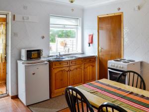 a kitchen with a sink and a stove and a table at Russets East Wing in Isle Brewers