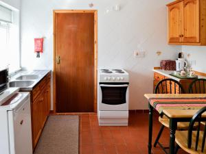 a kitchen with a stove and a sink and a table at Russets East Wing in Isle Brewers