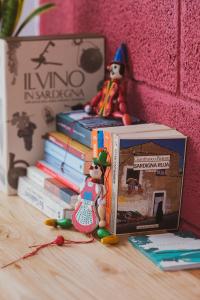 un gruppo di giocattoli seduti accanto a un mucchio di libri di Binzas betzas Agriturismo a Sedilo