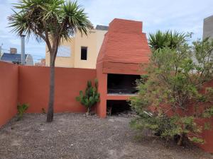 una casa con techo rojo y una palmera en Duplex Patagonia y Mar en Playa Unión