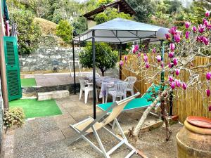 una mesa y sillas bajo una sombrilla en un jardín en L'ulivo, en Levanto