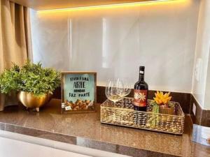 a counter with a bottle of wine and a sign at #1306T# Apartamento 1Q Luxuoso, Metropolitan Sidney Jd. Goiás in Goiânia