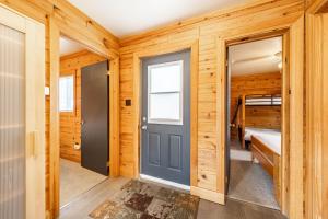 una puerta en una cabaña de madera con un dormitorio en Oakview Lodge & Marina, en Algonquin Highlands