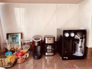 um balcão de cozinha com comodidades para preparar café e um micro-ondas em #1306T# Apartamento 1Q Luxuoso, Metropolitan Sidney Jd. Goiás em Goiânia