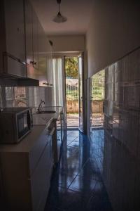 eine Küche mit einer Spüle und einer Mikrowelle in der Unterkunft Sea View in Celle Ligure