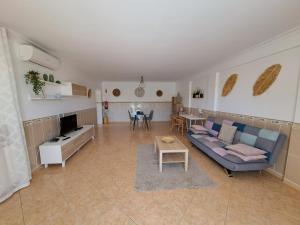 sala de estar con sofá azul y mesa en Villa Mariamar, en Albufeira