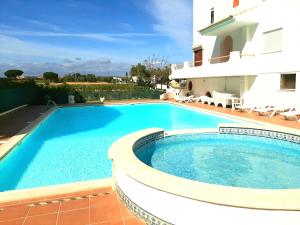 a swimming pool in front of a villa at Apartment Amalia in Albufeira