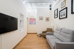 ein Wohnzimmer mit einem Sofa und einem Flachbild-TV in der Unterkunft Lupa Luxury Apartment in Rom