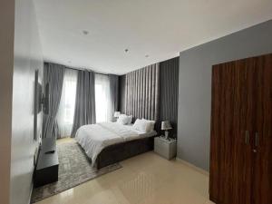 een slaapkamer met een bed en een televisie. bij Classic 2-bedroom condo in Lagos