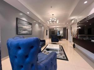 een woonkamer met een blauwe bank en een tafel bij Classic 2-bedroom condo in Lagos
