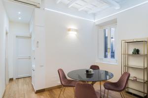 ein Esszimmer mit einem Tisch und Stühlen in der Unterkunft Lupa Luxury Apartment in Rom