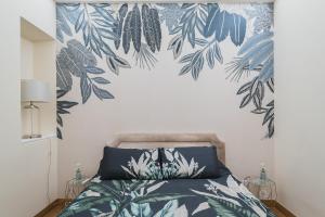ein Schlafzimmer mit einem Bett mit einer blau-grünen, grünen Wand in der Unterkunft Lupa Luxury Apartment in Rom
