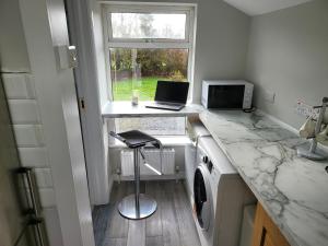 a kitchen with a counter with a laptop and a window at Peaceful Farm Cottage in Menlough near Mountbellew, Ballinasloe, Athlone & Galway in Galway