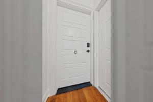 a white door in a room with a wooden floor at Beautiful Condo close to Saucy Brew Works - G in Sandusky