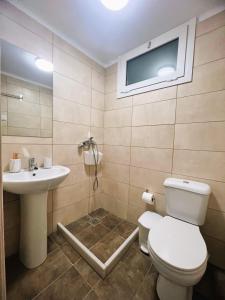 a bathroom with a toilet and a sink at Pasiphae Heraklion Apartment in Heraklio Town