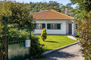 una casa con un cancello di fronte a un cortile di Villa Coral - Private Heated Pool & Hot tub a Famalicão