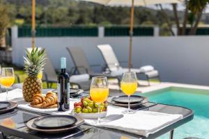 una mesa con copas de vino y un plato de comida en Villa Coral - Private Heated Pool & Hot tub en Famalicão