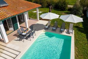 an overhead view of a pool with chairs and umbrellas at Villa Coral - Private Large Pool & Garden in Famalicão