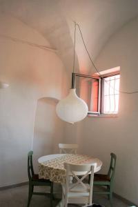 een tafel en stoelen in een kamer met een raam bij Casa Ninetta, tra mare e natura. in Finale Ligure