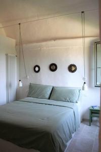 een slaapkamer met een bed met twee klokken aan de muur bij Casa Ninetta, tra mare e natura. in Finale Ligure